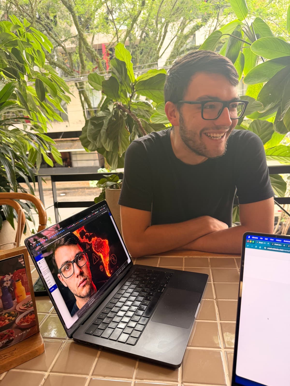 Two people chatting at a table while they work.